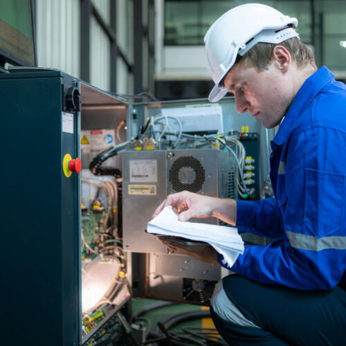 Technician working on the electrical control cabinet of robotic arm, Robotic arms industrial background